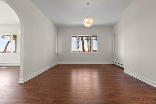 empty room with dark wood-type flooring, baseboards, arched walkways, and baseboard heating