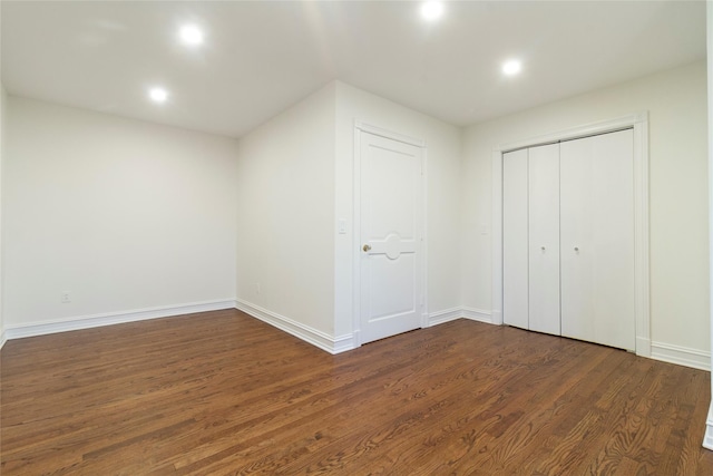 unfurnished bedroom featuring dark wood-type flooring, baseboards, and recessed lighting