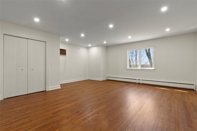 unfurnished bedroom with recessed lighting, wood finished floors, baseboards, and baseboard heating