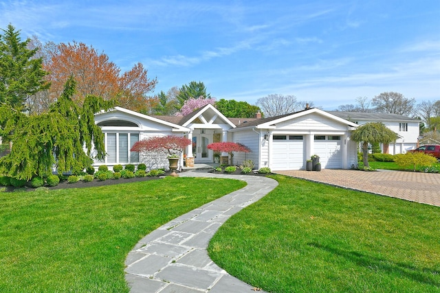 view of front of house featuring a garage, driveway, and a front lawn