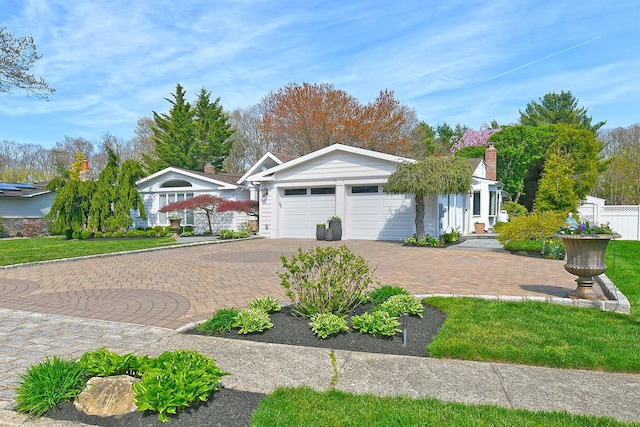 view of front of property with a garage, driveway, and fence