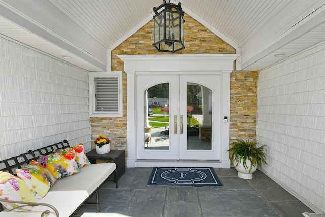 property entrance featuring stone siding and french doors
