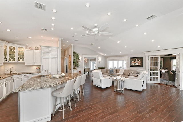 kitchen with recessed lighting, vaulted ceiling, visible vents, and open floor plan