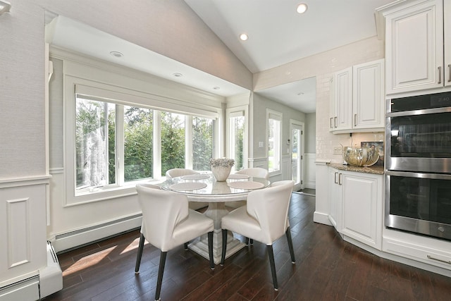 dining space featuring a baseboard heating unit, plenty of natural light, vaulted ceiling, and dark wood-style flooring