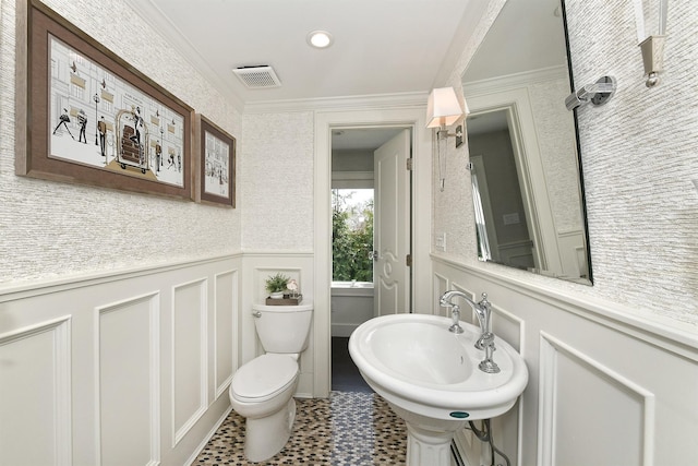 bathroom with a decorative wall, a wainscoted wall, toilet, ornamental molding, and visible vents