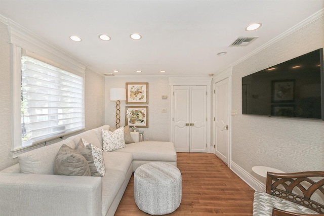 living area with crown molding, wood finished floors, visible vents, and recessed lighting