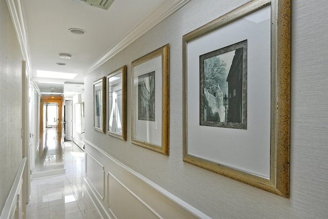 corridor featuring visible vents, crown molding, and a wainscoted wall