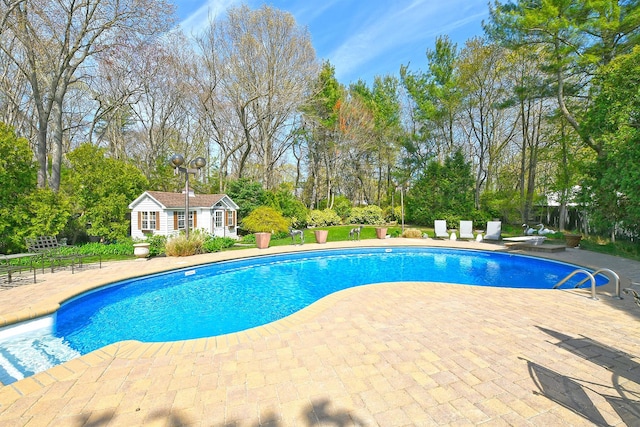 outdoor pool featuring an exterior structure, a patio, and an outdoor structure