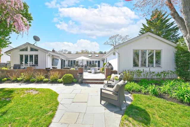 back of house with a yard and a patio area