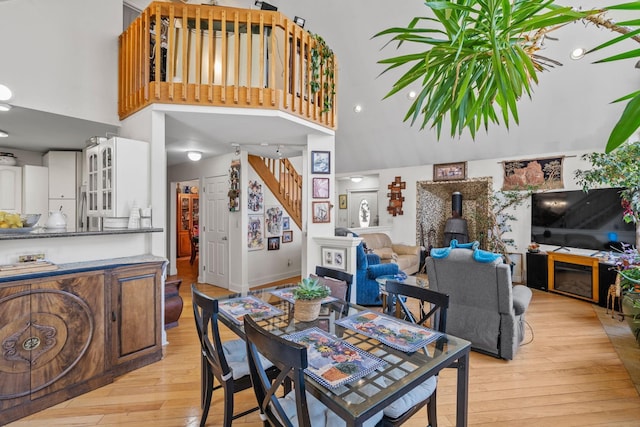225 Toleman Rd, Washingtonville, NY 10992 - dining space featuring light wood-type flooring, a wood stove, a towering ceiling, and stairway