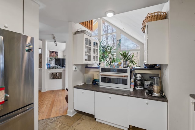 225 Toleman Rd, Washingtonville, NY 10992 - kitchen with freestanding refrigerator, dark countertops, baseboards, white oven, and white cabinets