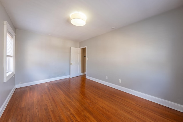 unfurnished room with wood finished floors and baseboards