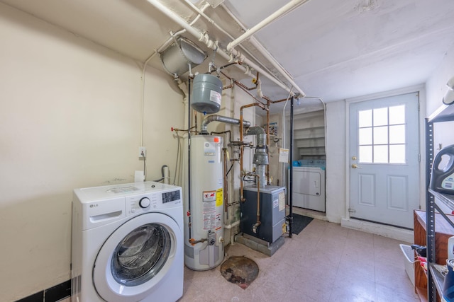 clothes washing area featuring washer / clothes dryer, laundry area, gas water heater, and a heating unit