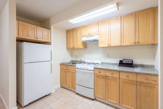 kitchen with light brown cabinetry, under cabinet range hood, a sink, and white appliances