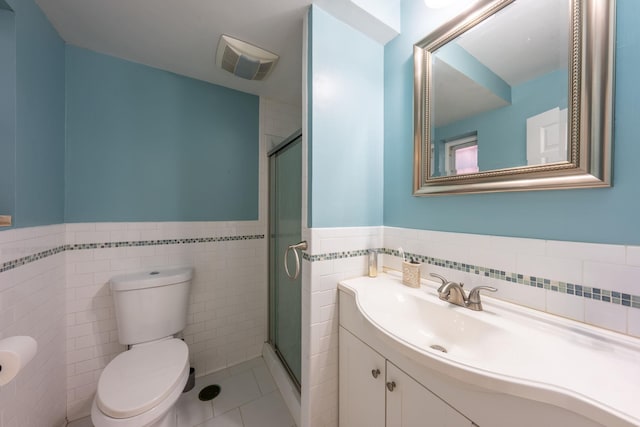 bathroom featuring toilet, a stall shower, visible vents, and a wainscoted wall