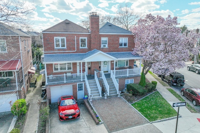 view of front of property featuring an attached garage, covered porch, stairway, brick siding, and driveway