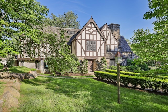 86 Hereford Rd, Bronxville, NY 10708 - tudor home featuring stucco siding, a chimney, a front yard, and stone siding