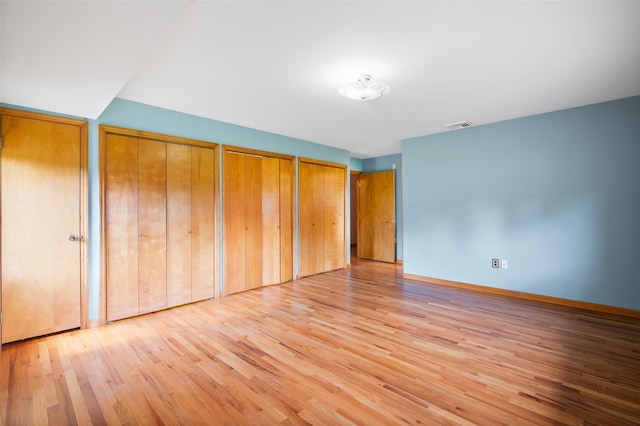 370 Forest Rd, Wallkill, NY 12589 - unfurnished bedroom featuring wood finished floors, two closets, and baseboards