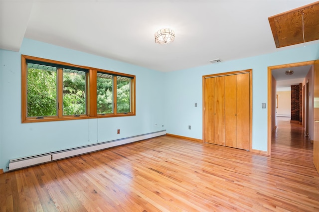 370 Forest Rd, Wallkill, NY 12589 - unfurnished bedroom with baseboard heating, light wood-style flooring, attic access, a baseboard radiator, and baseboards