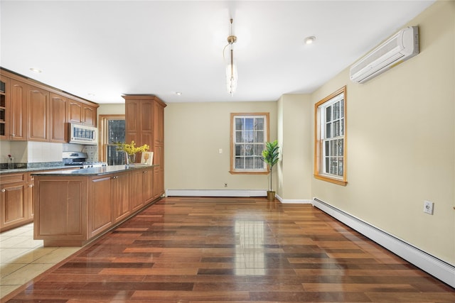 kitchen featuring white microwave, glass insert cabinets, a wall unit AC, a baseboard radiator, and stainless steel range