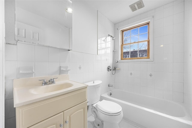 bathroom featuring vanity, shower / tub combination, toilet, visible vents, and tile walls