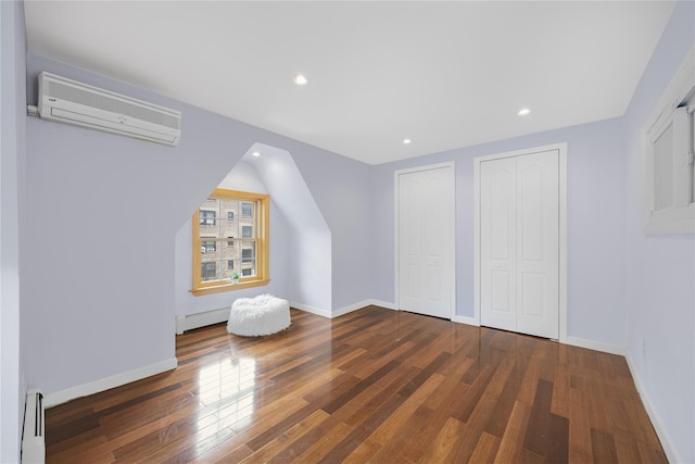 bonus room with a wall mounted air conditioner, baseboards, a baseboard heating unit, and hardwood / wood-style floors