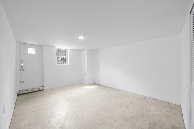 basement featuring tile patterned floors and baseboards