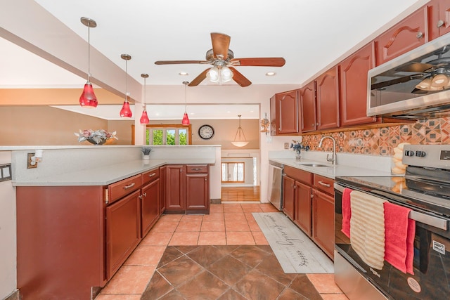 kitchen featuring appliances with stainless steel finishes, a sink, light countertops, a ceiling fan, and tasteful backsplash