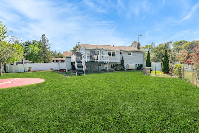 back of property with a deck, a fenced backyard, a chimney, a lawn, and stairway