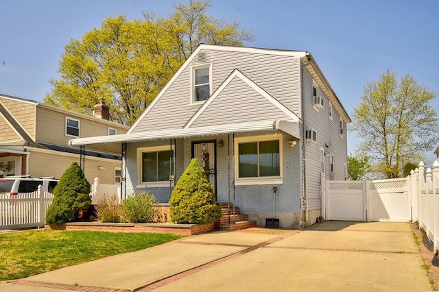 bungalow-style house featuring covered porch, brick siding, fence, and a gate