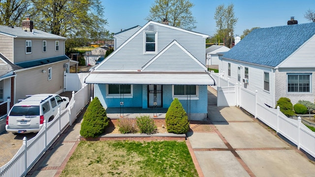 bungalow featuring covered porch, a gate, brick siding, and a fenced backyard
