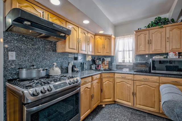 kitchen featuring decorative backsplash, a toaster, granite finish floor, under cabinet range hood, and appliances with stainless steel finishes