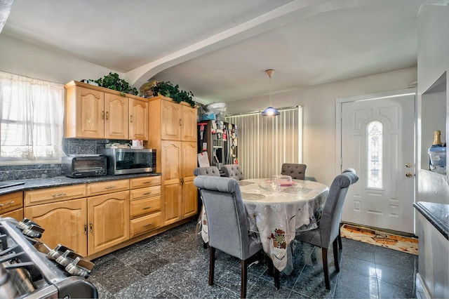 dining room with a toaster, a healthy amount of sunlight, and granite finish floor