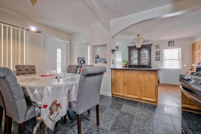 dining room featuring baseboards, arched walkways, and granite finish floor