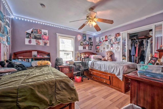 bedroom featuring crown molding, a closet, a ceiling fan, and wood finished floors