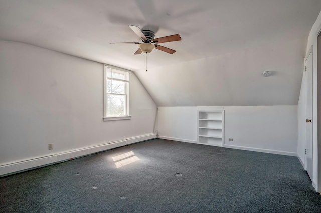 bonus room with a baseboard heating unit, built in features, a ceiling fan, dark colored carpet, and lofted ceiling