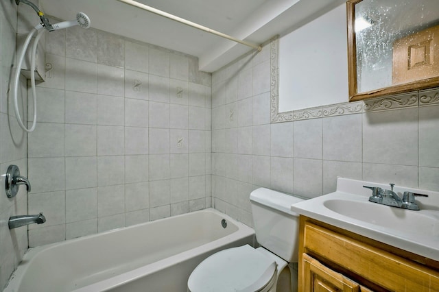 full bathroom with tile walls, bathing tub / shower combination, toilet, and vanity