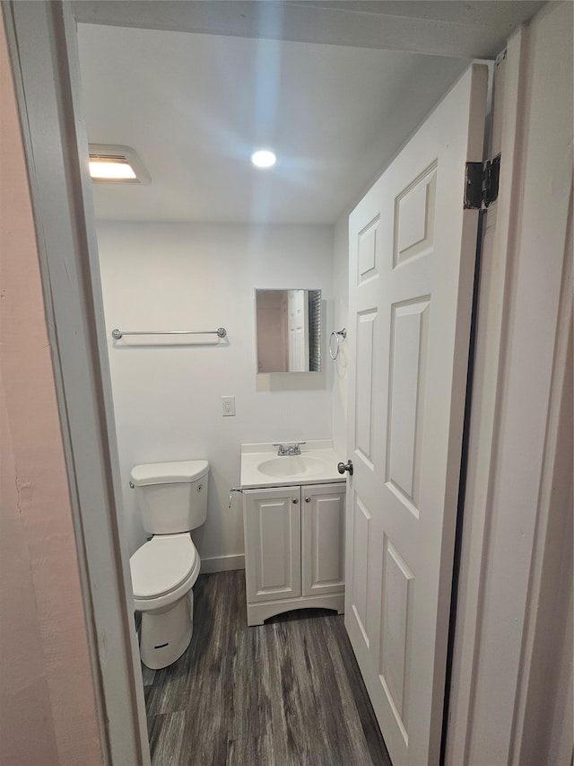 648 Lybolt Rd, Middletown, NY 10941 - half bathroom with baseboards, wood finished floors, vanity, and toilet