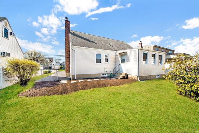 back of property with a chimney, fence, entry steps, and a lawn