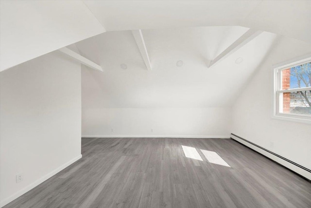 additional living space featuring baseboards, vaulted ceiling with beams, wood finished floors, and baseboard heating