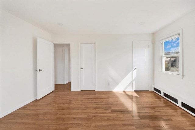 unfurnished bedroom with wood finished floors and baseboards
