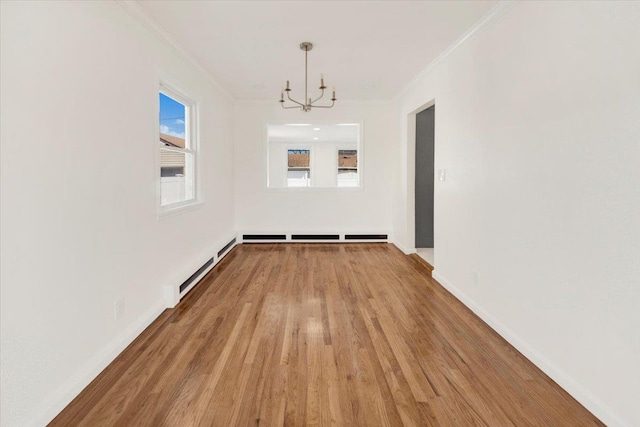 unfurnished dining area with baseboards, ornamental molding, a chandelier, and light wood-type flooring