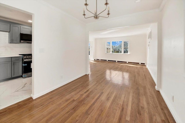 unfurnished dining area featuring baseboard heating, an inviting chandelier, ornamental molding, and light wood-type flooring