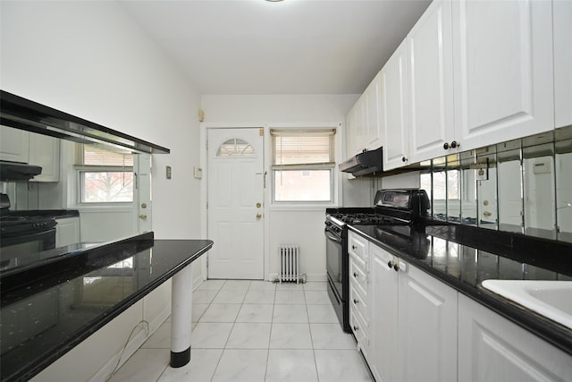 174-20 Jewel Ave, Fresh Meadows, NY 11365 - kitchen featuring under cabinet range hood, white cabinetry, black gas range oven, and radiator heating unit