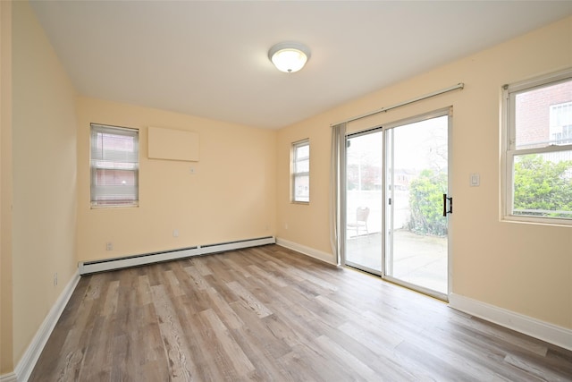 174-20 Jewel Ave, Fresh Meadows, NY 11365 - spare room with a healthy amount of sunlight, baseboards, a baseboard heating unit, and light wood-style flooring