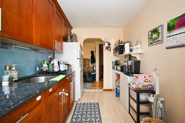 174-20 Jewel Ave, Fresh Meadows, NY 11365 - kitchen with backsplash, arched walkways, a sink, freestanding refrigerator, and dark stone counters