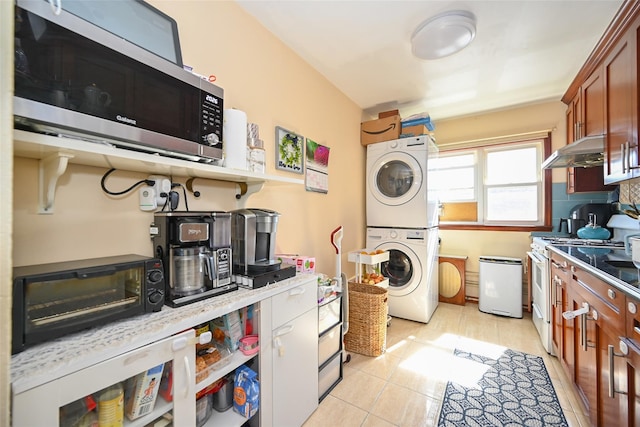 174-20 Jewel Ave, Fresh Meadows, NY 11365 - kitchen with stacked washer / dryer, a toaster, stainless steel microwave, under cabinet range hood, and white range with gas stovetop
