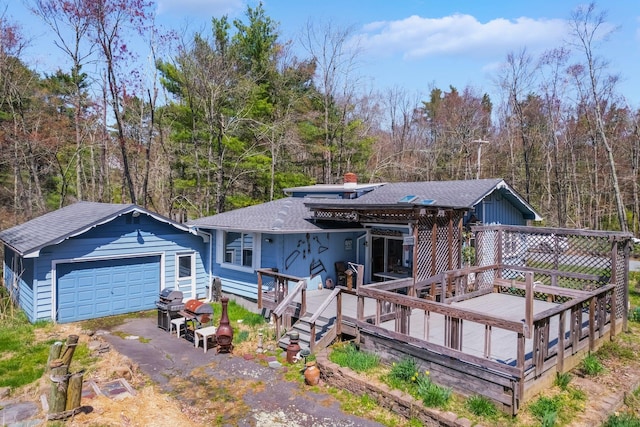 236 Lakeview Drive Rd, Eldred, NY 12743 - view of front of home featuring a garage, a wooden deck, a chimney, a shingled roof, and a wooded view