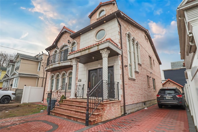 view of front of house featuring fence and a balcony