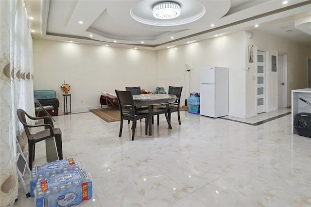 dining area with recessed lighting, marble finish floor, a tray ceiling, and baseboards